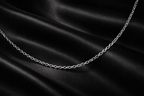 Silver chain on black satin fabric