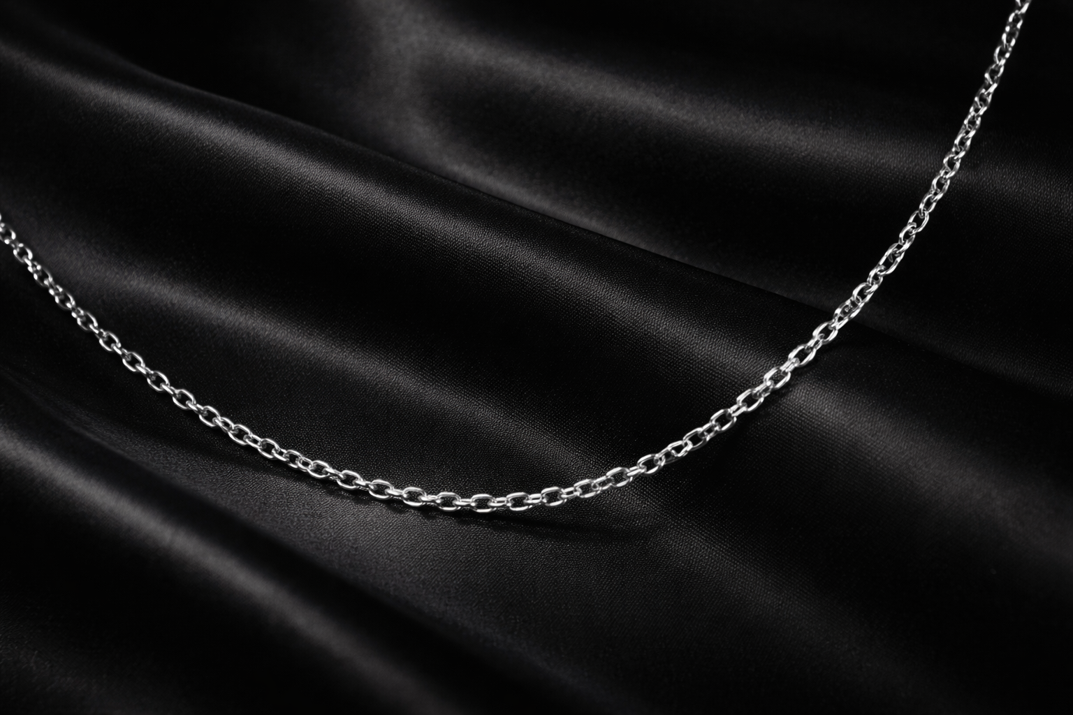 Silver chain on black satin fabric