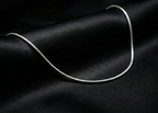 Silver necklace on a black fabric background