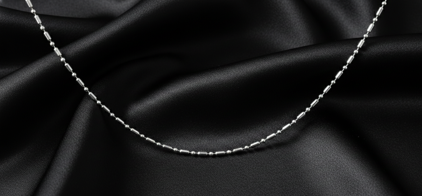 Silver chain necklace on black satin fabric