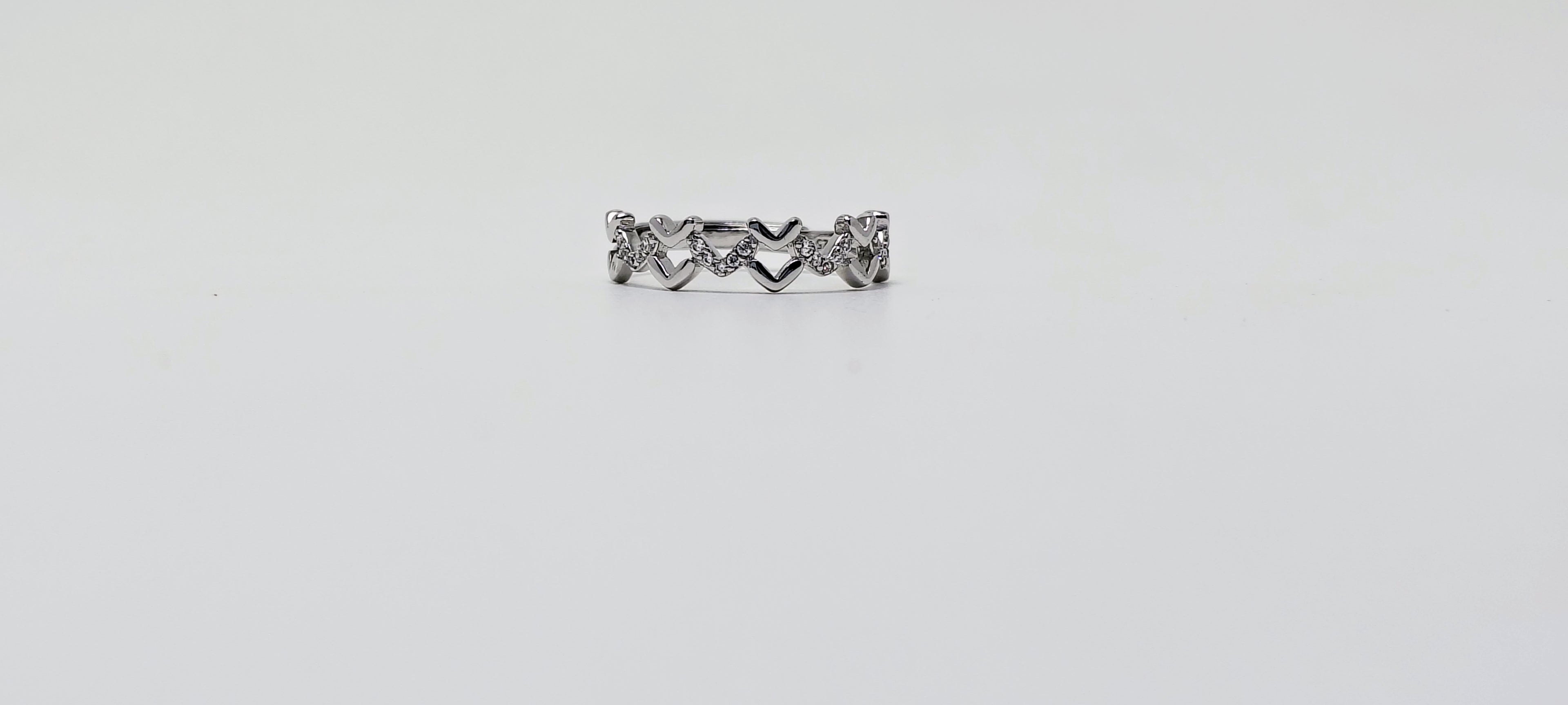 Silver ring with heart and arrow design on a white background