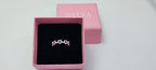Silver ring in a pink box with 'SYLVIA' branding on a white background