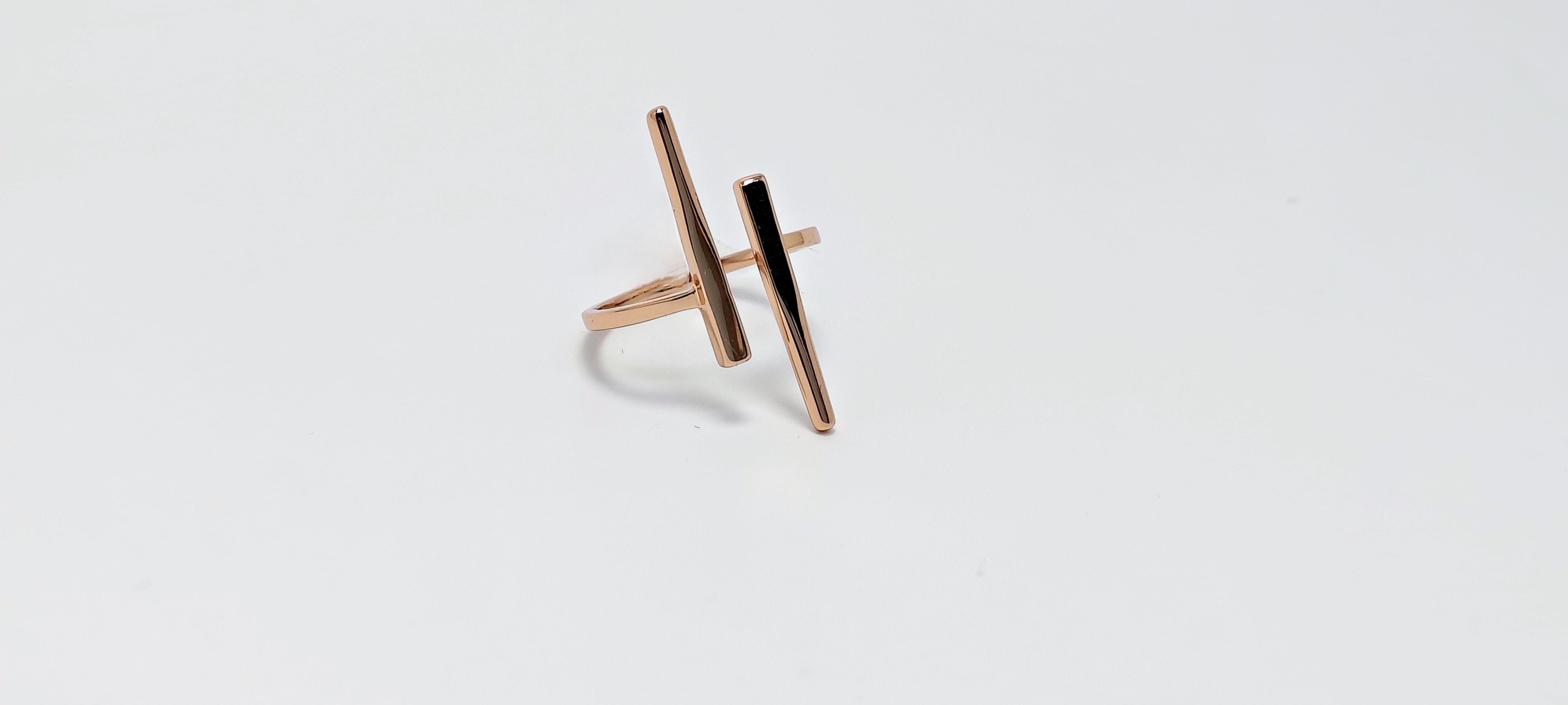 Rose gold ring with a black accent on a light gray background