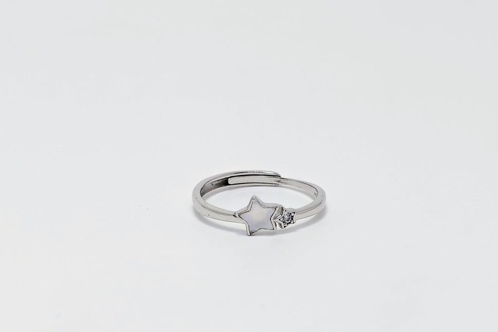 Silver ring with a star design on a light gray background