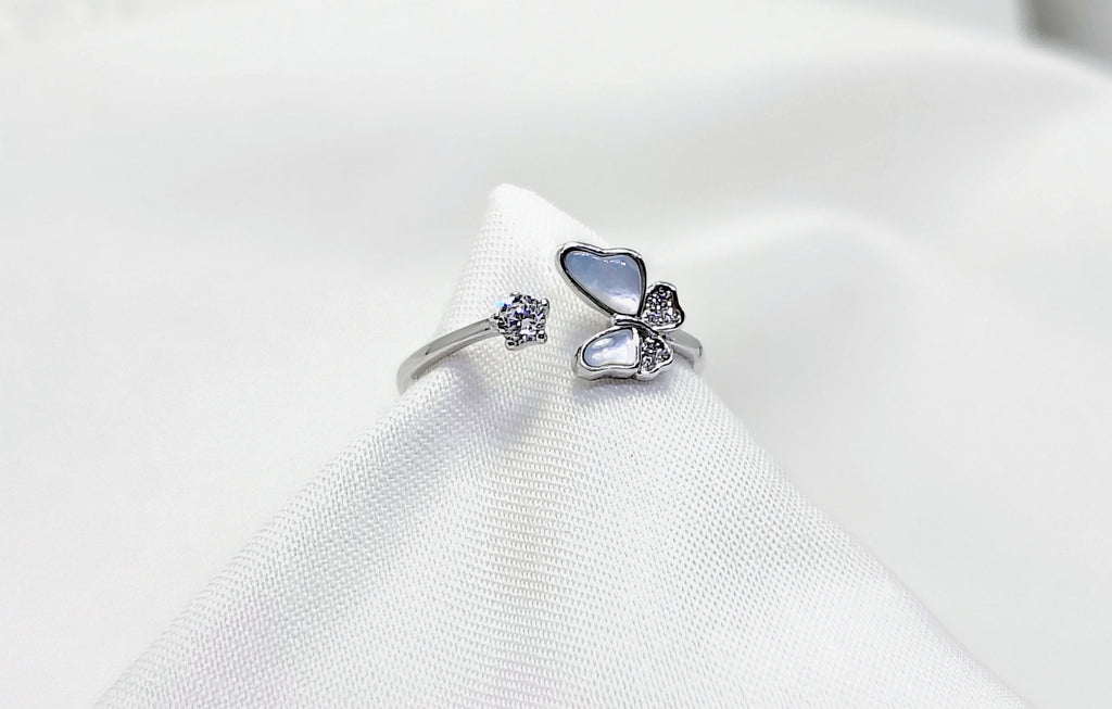 Silver ring with blue gemstone on a white cushion