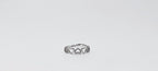 Silver ring with intricate design on a light gray background