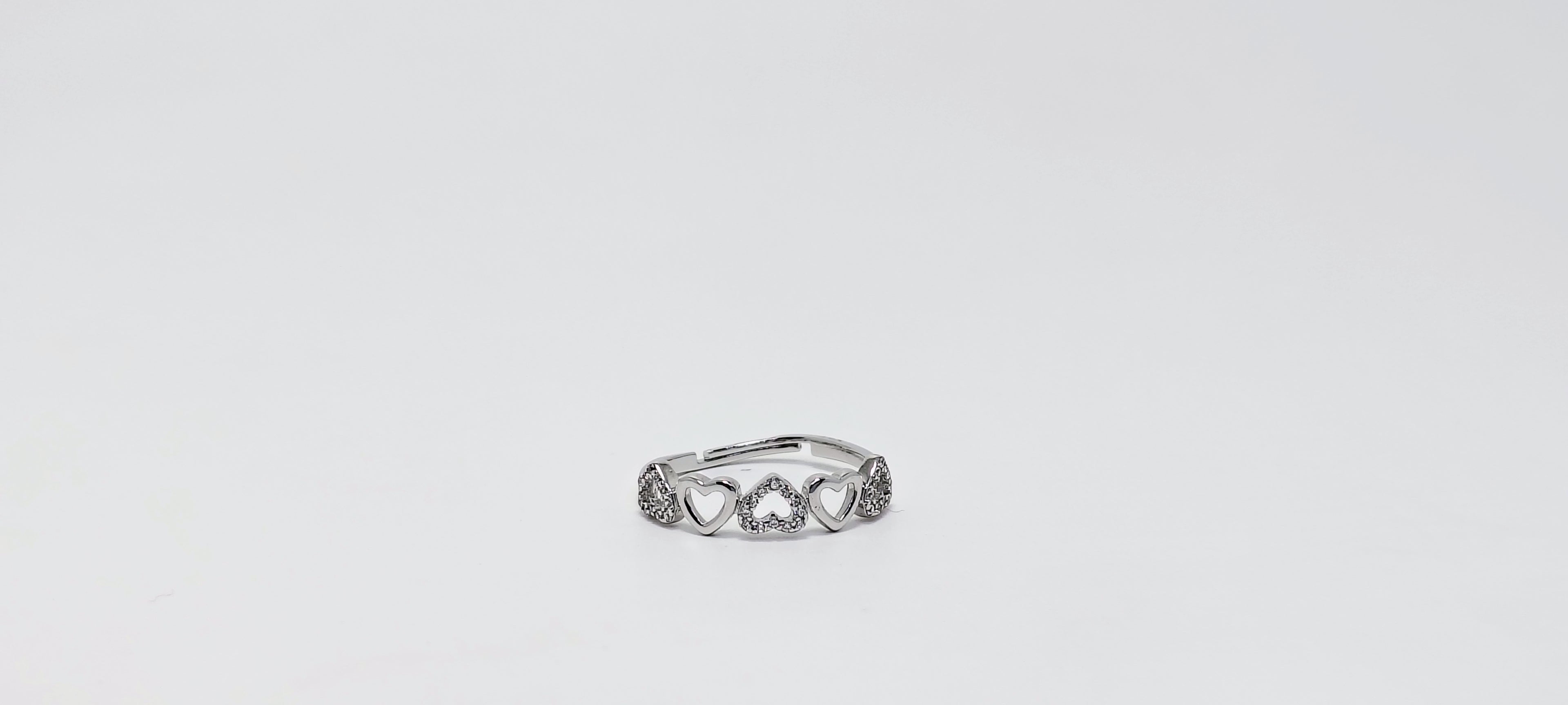 Silver ring with intricate design on a light gray background