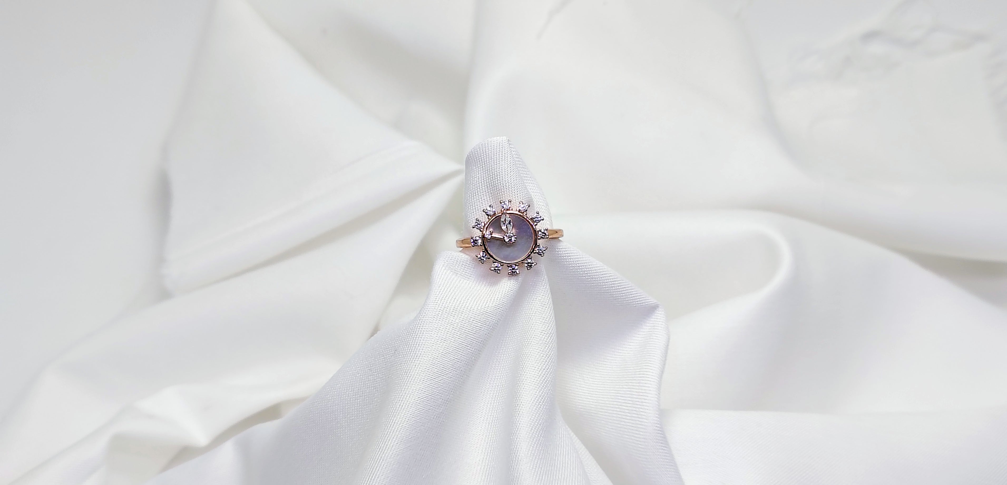 Ring with a central gemstone on a white fabric background