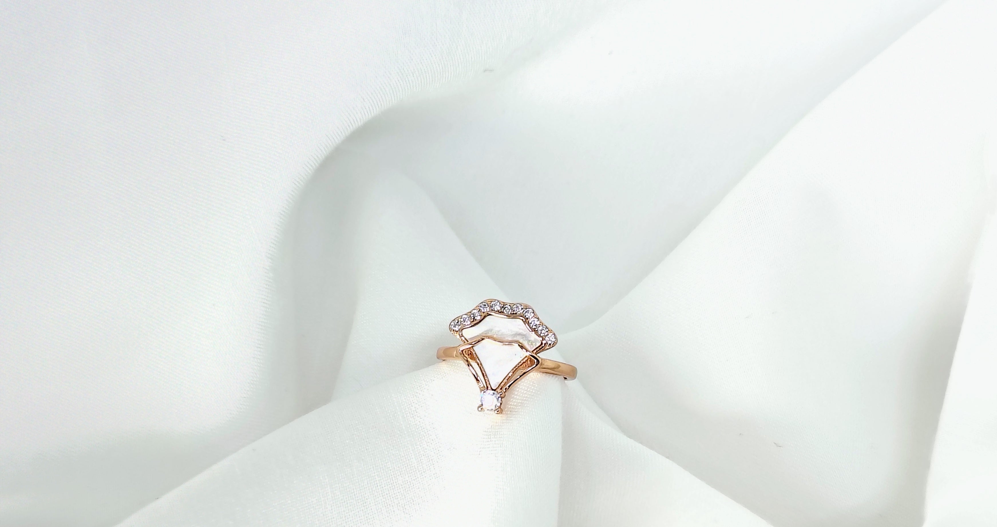 Ring with a heart-shaped diamond on a white fabric background
