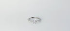 Silver ring with a diamond on a light gray background