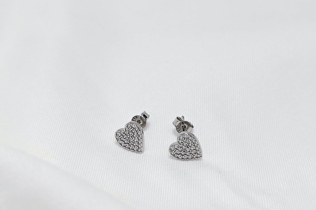 Pair of silver heart-shaped earrings on a white background