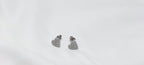 Pair of silver heart-shaped earrings on a white background