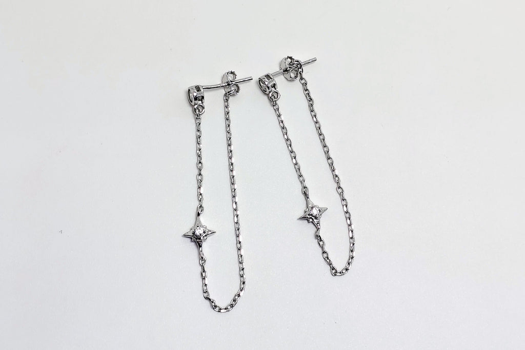Silver chain bracelet with star-shaped ends on a light gray background