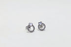 Pair of silver earrings with gemstones on a white background