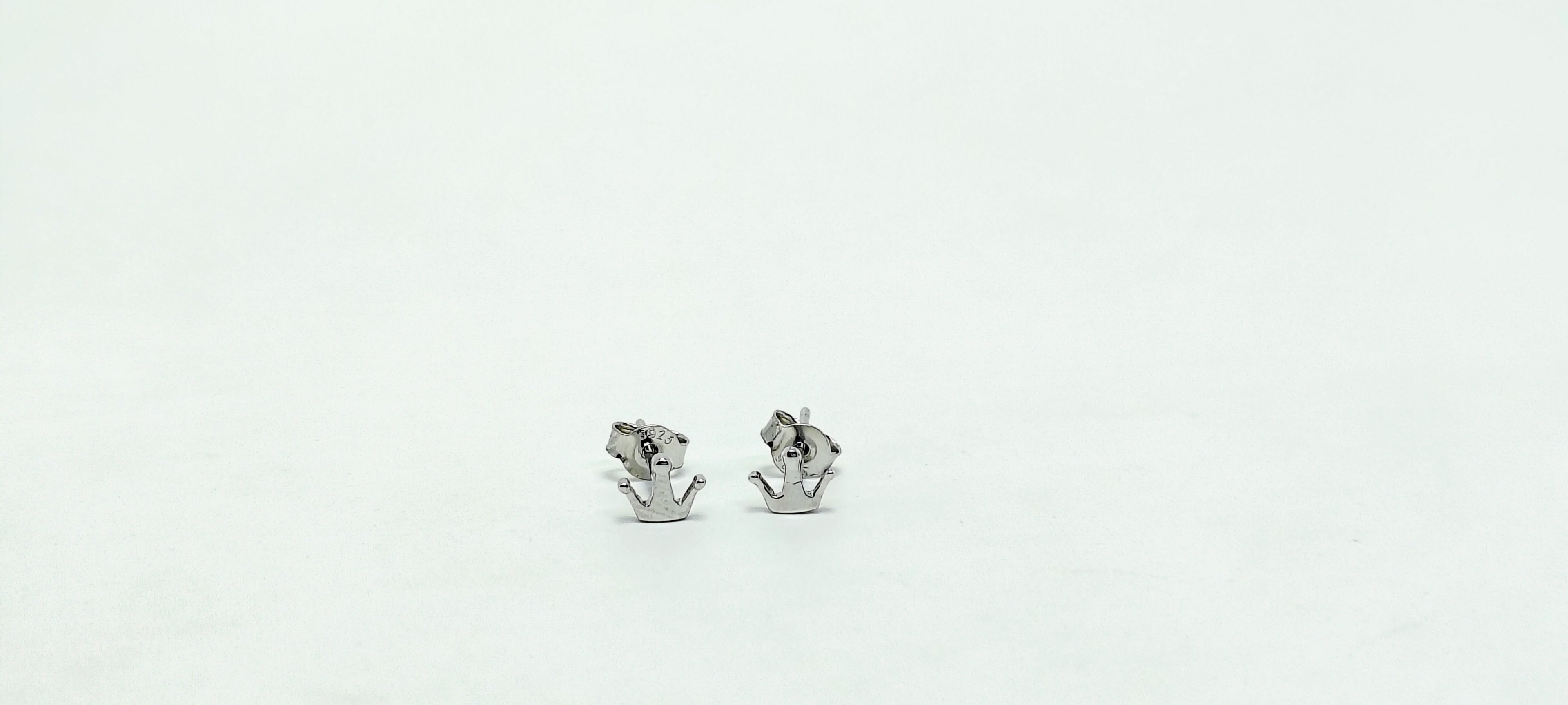Pair of silver anchor-shaped earrings on a white background