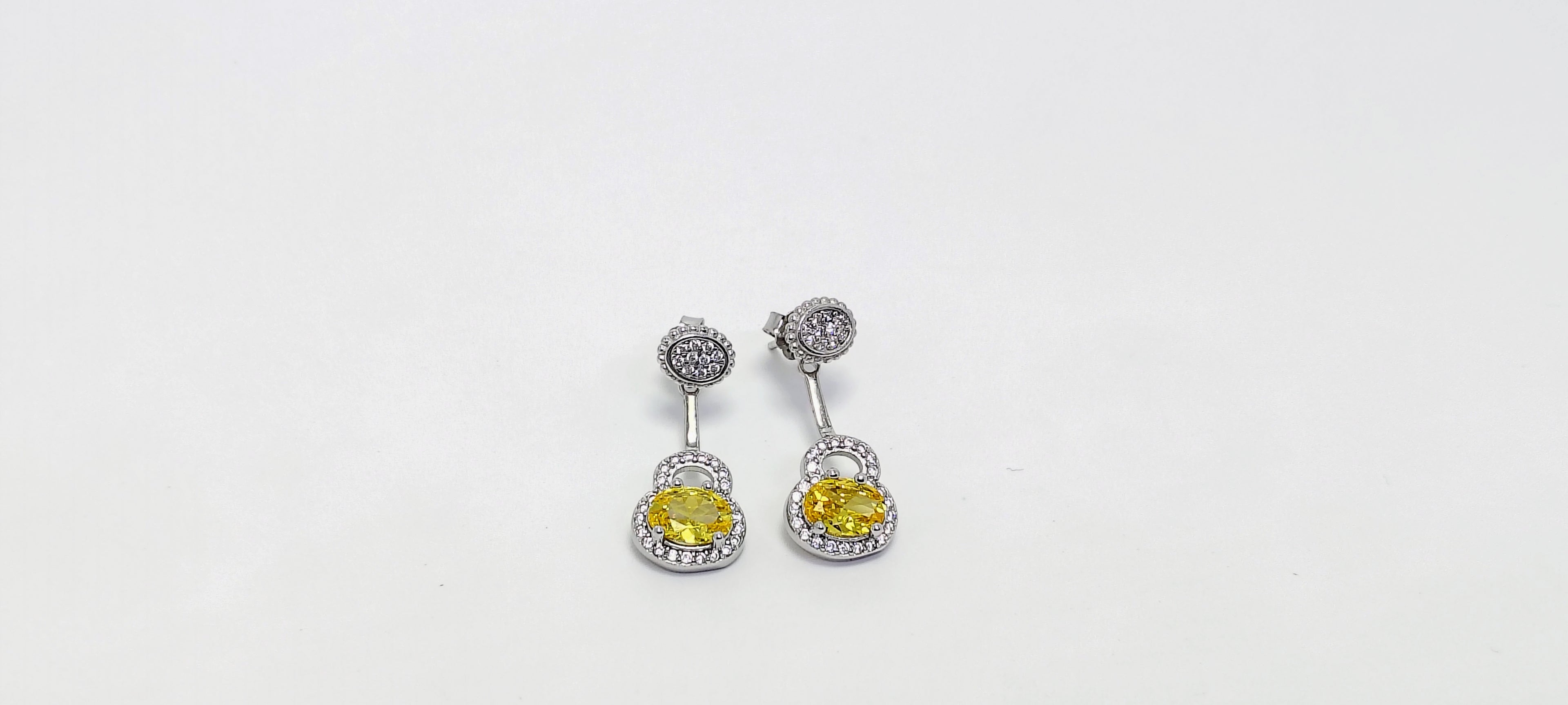 Pair of earrings with yellow gemstones on a white background