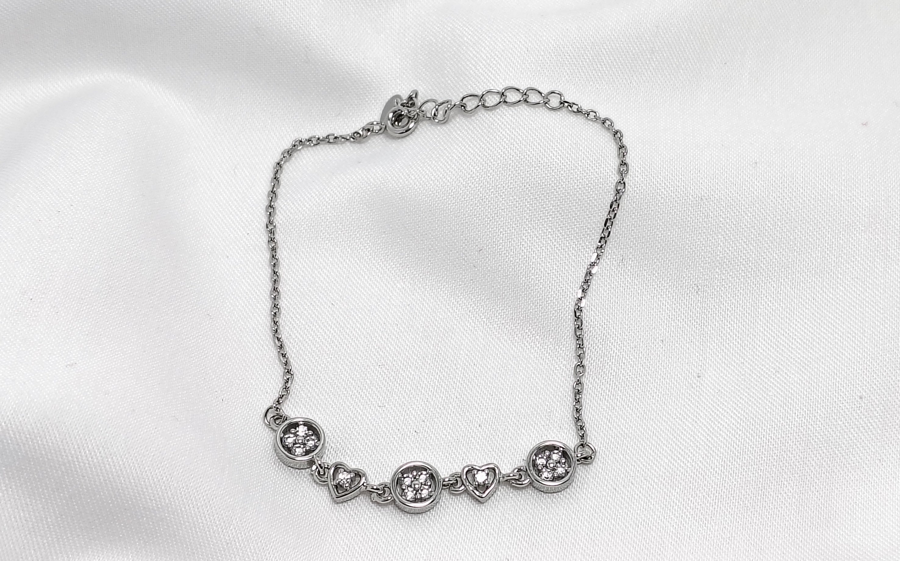 Silver bracelet on a white fabric background