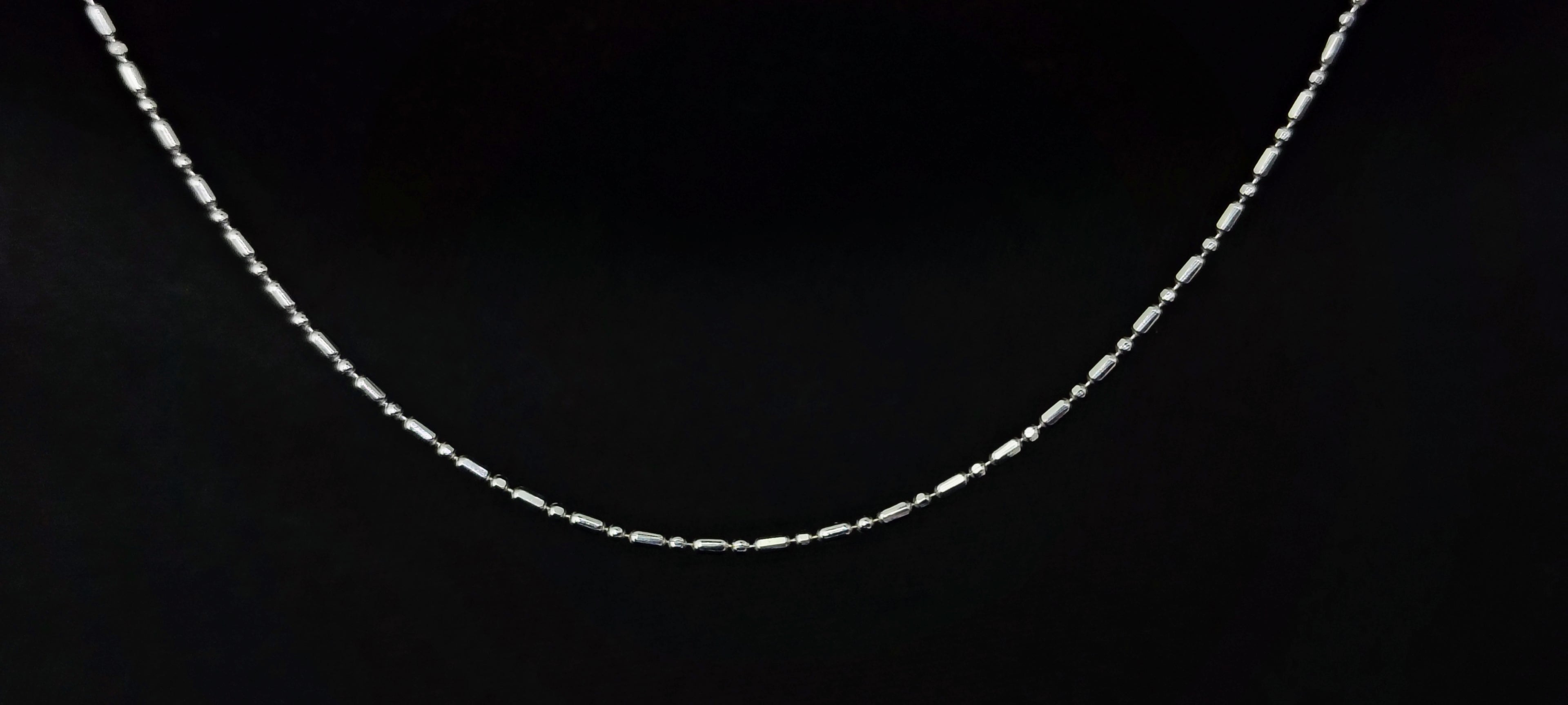 Silver chain necklace on a black background